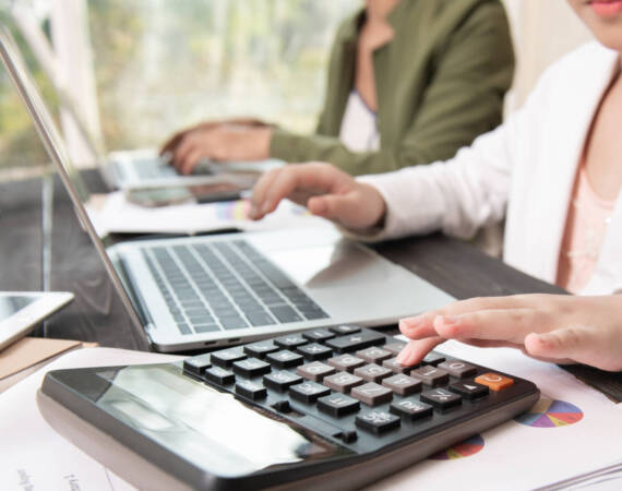 Business woman working teamwork process, Business team using a calculator to calculate the numbers of statistic business profits growth rate on documents graph data, his desk in a office.